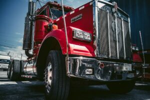 En röd Kenworth-lastbil fotograferad underifrån för inspektion av skick.