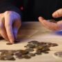Person räknar mynt vid ett bord för att bygga en ekonomisk buffert