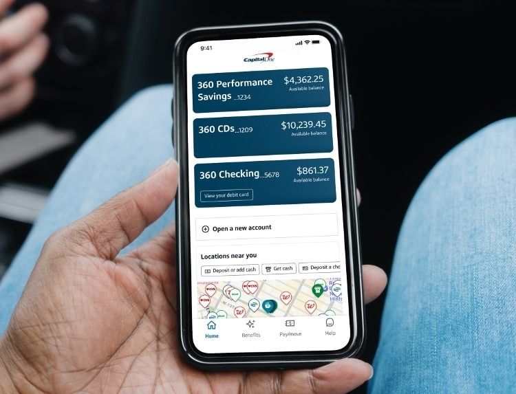 Hand håller en smartphone med bankappens spar- och kontosaldon